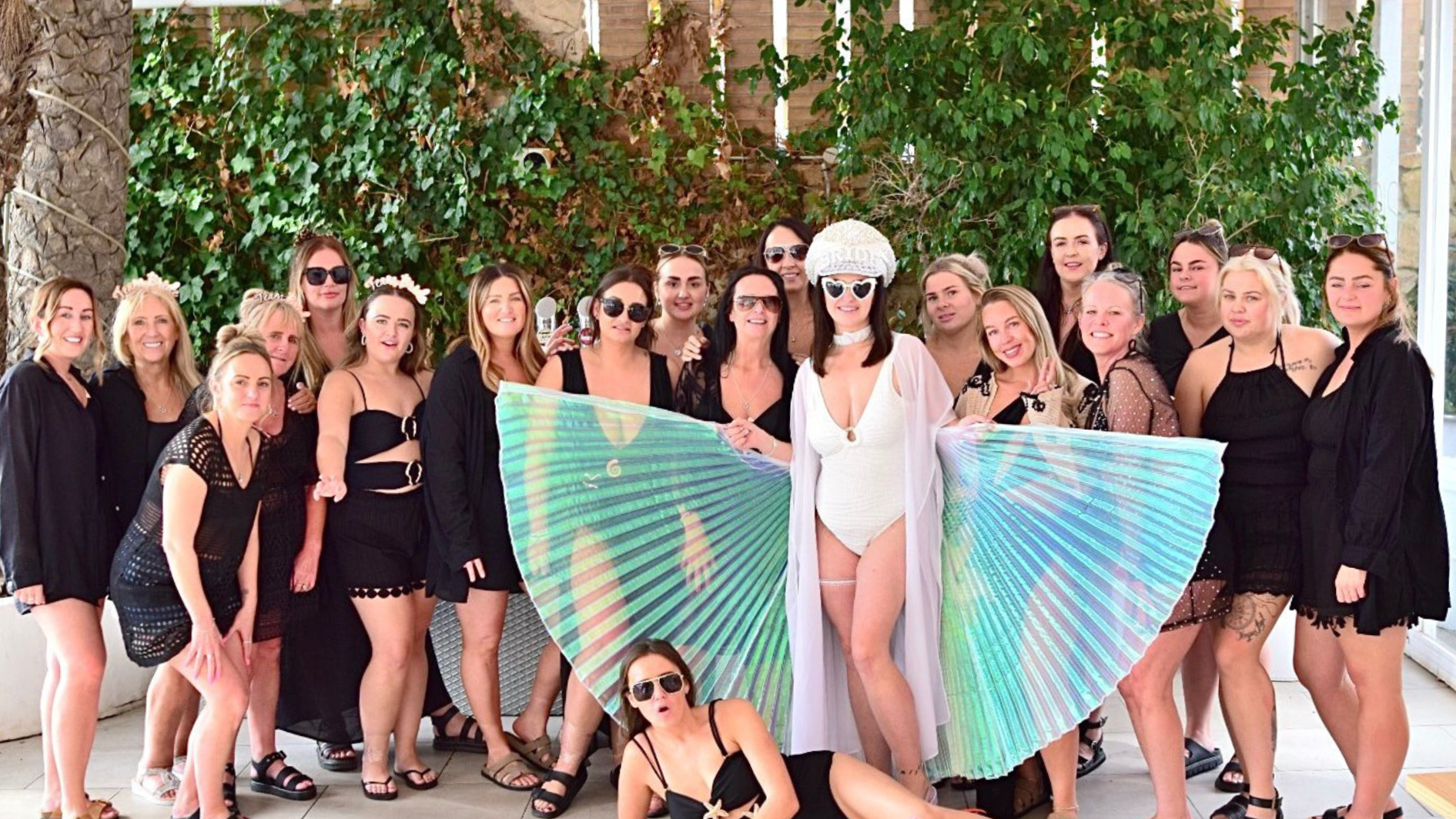 bride in wings with hen party